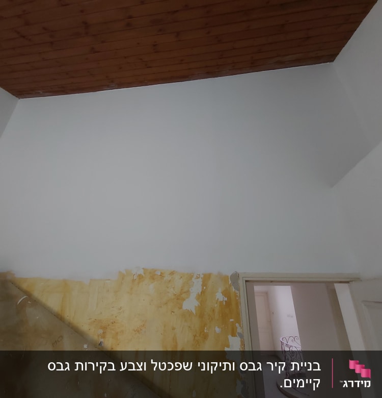 קיר גבס עם סימני צבע מתקלף ליד מדרגות